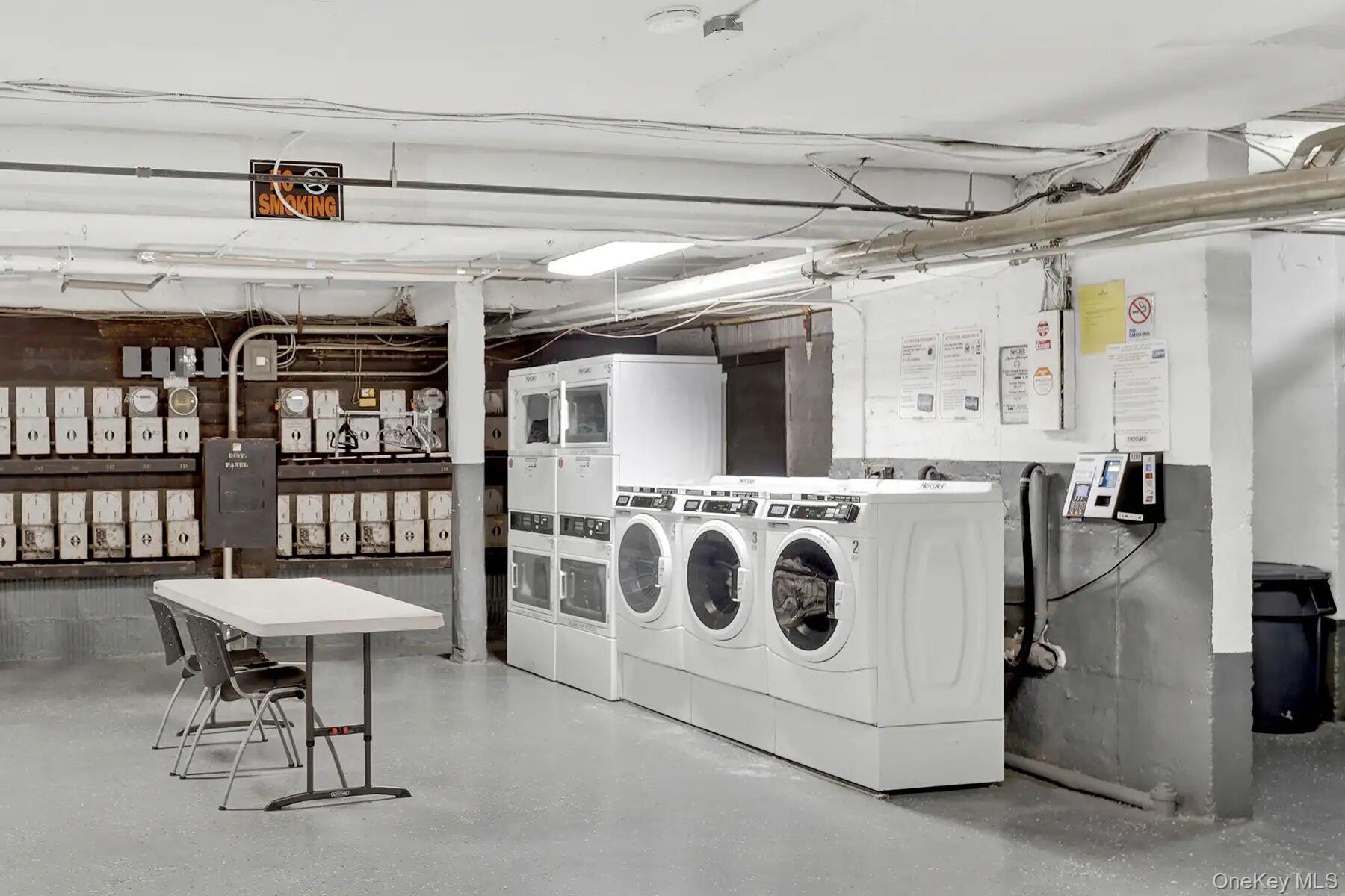 1 Ash Place, Unit 3A Great Neck, NY 11021 - Photo 2 of 10 Dedicated laundry facility featuring multiple front-loading washers and dryers, utility sinks, and commercial-grade flooring