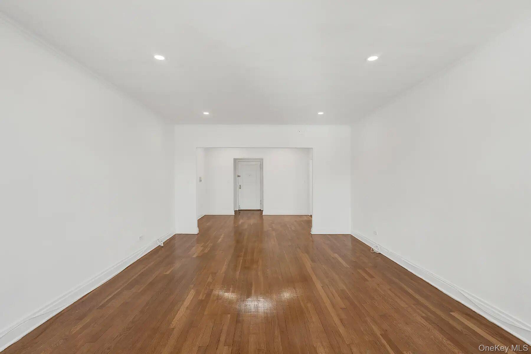 1 Ash Place, Unit 3A Great Neck, NY 11021 - Photo 5 of 10 Expansive interior space featuring wood-finish flooring, white walls, recessed ceiling lighting, white baseboards, and a white ceiling