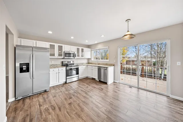 a kitchen with stainless steel appliances granite countertop a refrigerator and a sink
