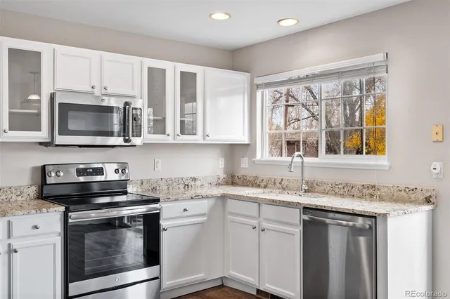 a kitchen with stainless steel appliances granite countertop a stove a sink and a microwave