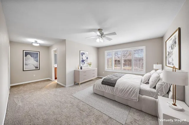 a spacious bedroom with a large bed a couch and a window