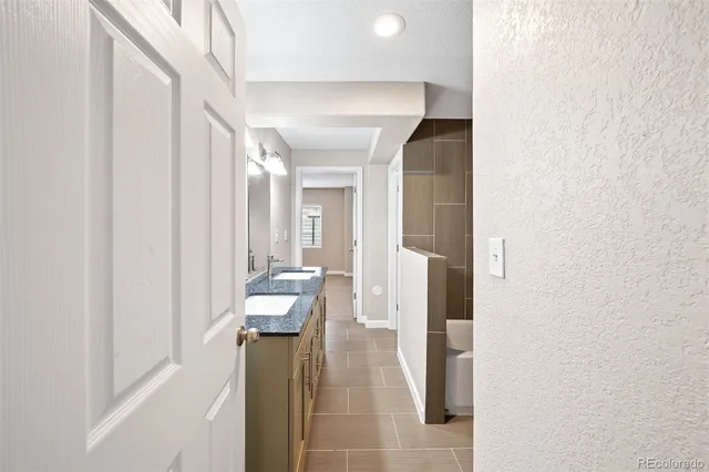 a hallway with white cabinets and wooden floor