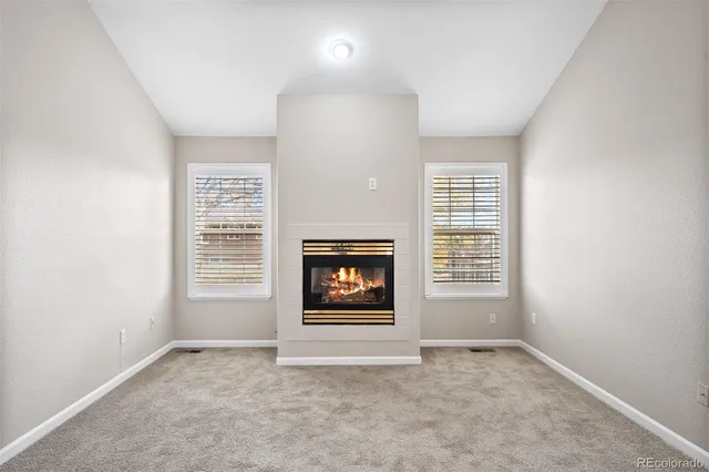 an empty room with a window and a fireplace