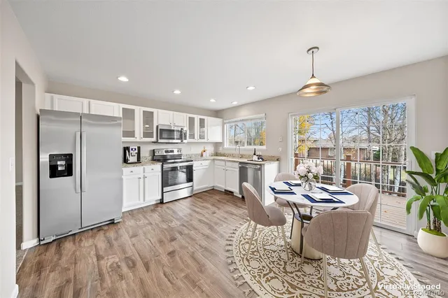a kitchen with a table chairs refrigerator and microwave