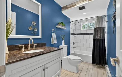 a bathroom with a granite countertop sink toilet and shower