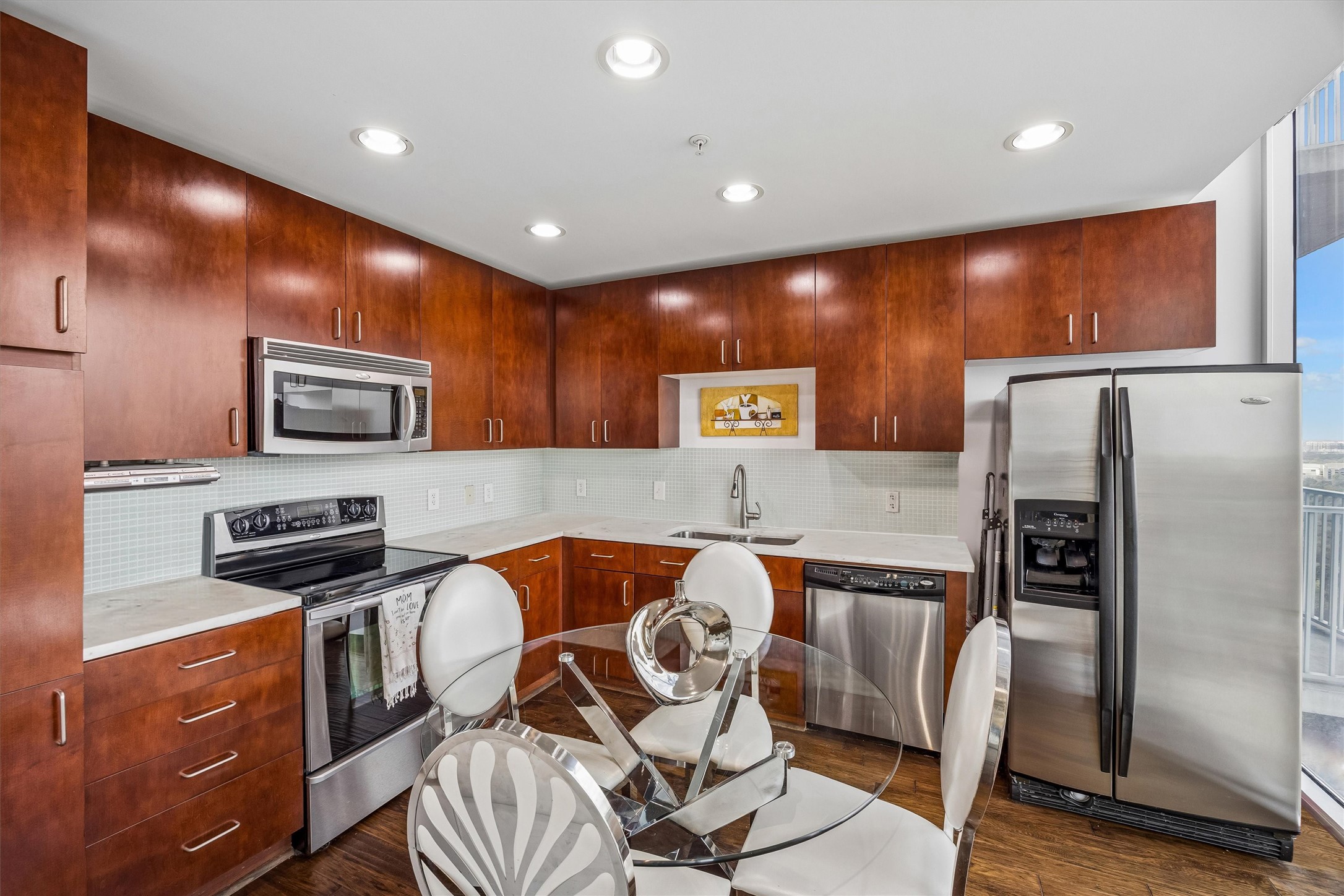 5925 Almeda Road, Unit 11907 Houston, TX 77004 - Photo 9 of 35 a kitchen with stainless steel appliances granite countertop a refrigerator and a stove top oven with wooden floor