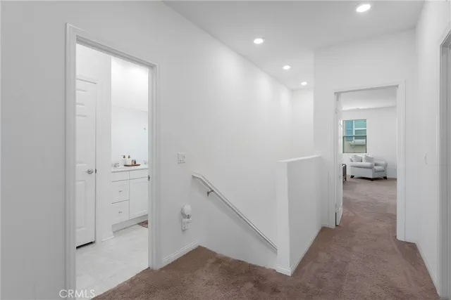 a view of a hallway with a livingroom and a bathroom