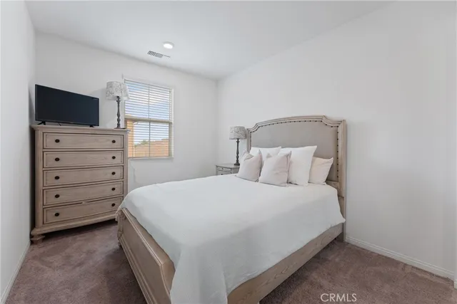 a bedroom with a large bed and a flat screen tv