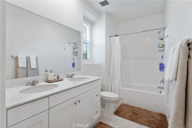 a bathroom with a granite countertop sink a toilet and shower