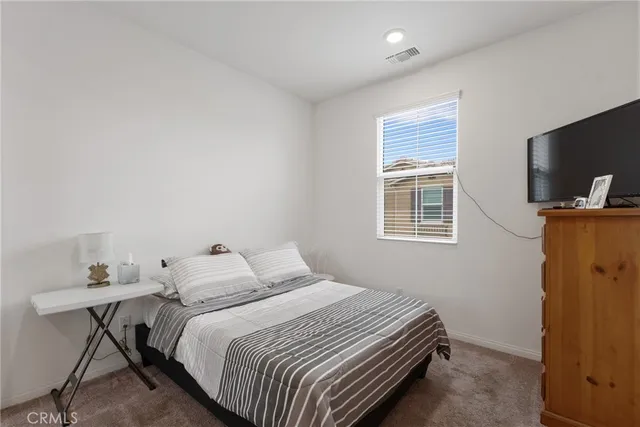 a bedroom with a bed and flat screen tv