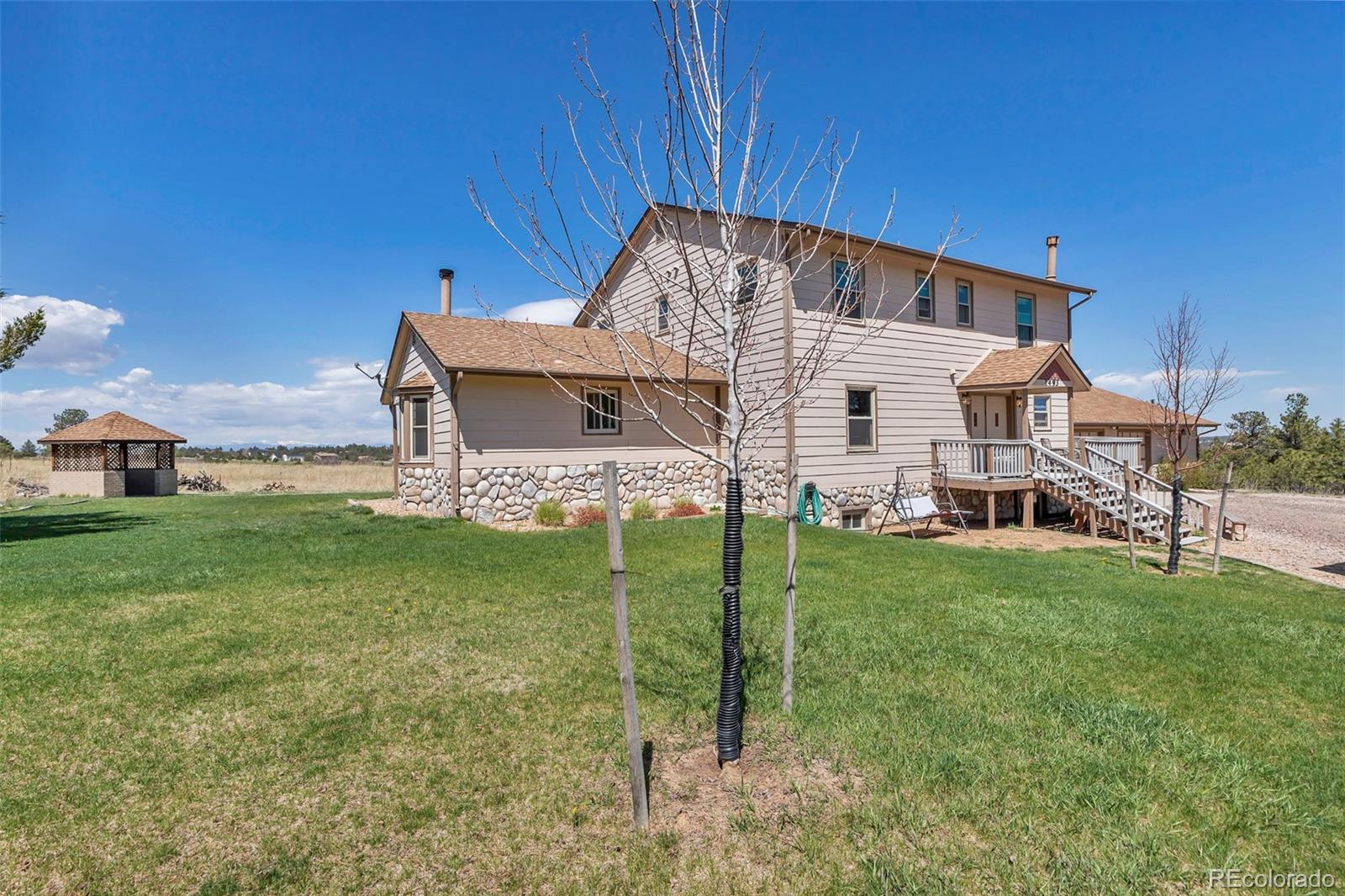 1493 Flintwood Road Franktown, CO 80116 - Photo 14 of 31 a view of a house with a backyard