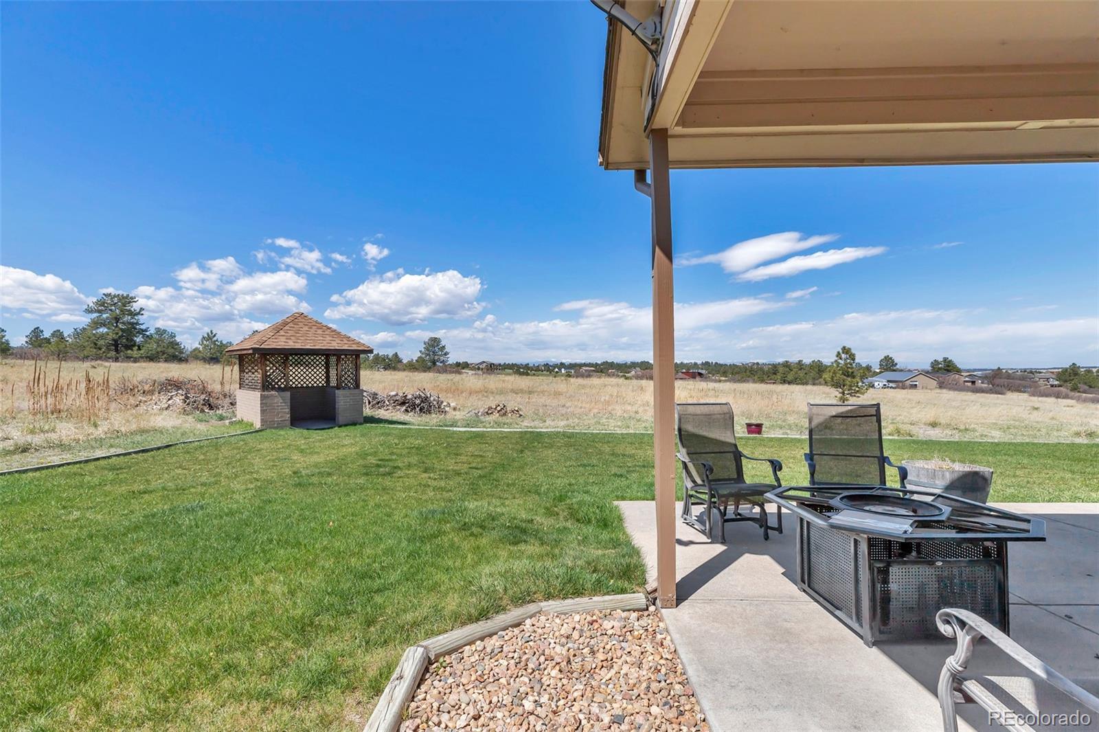 1493 Flintwood Road Franktown, CO 80116 - Photo 15 of 31 a view of a terrace with a table and chairs