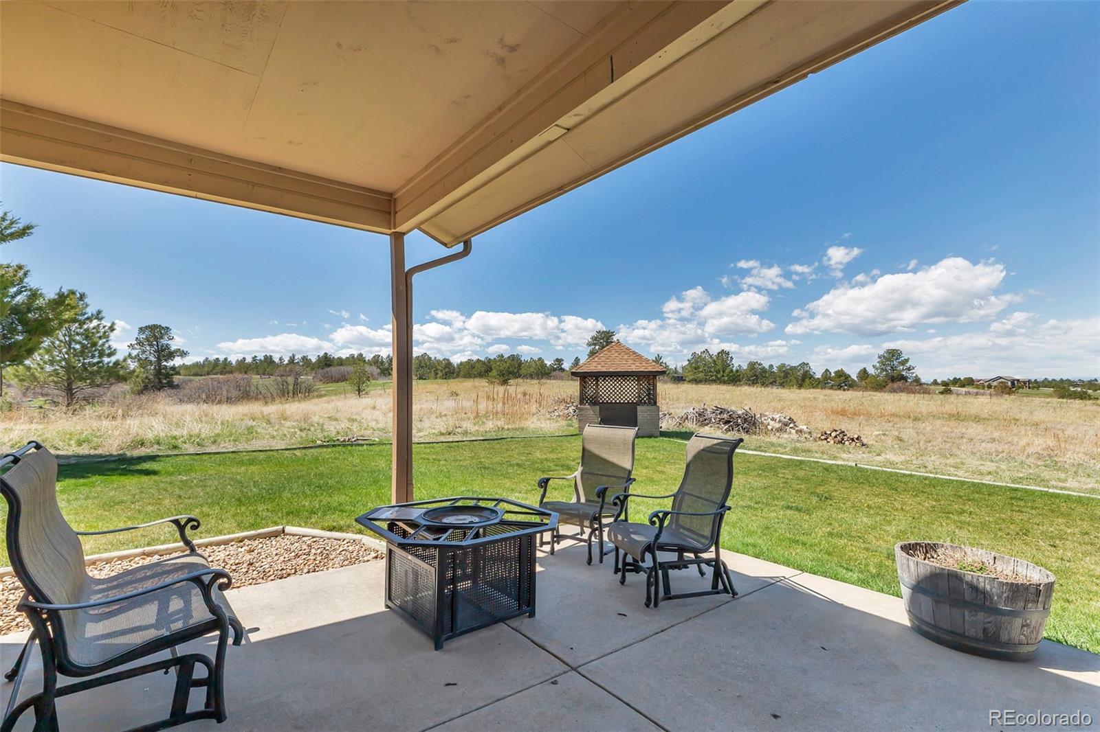 1493 Flintwood Road Franktown, CO 80116 - Photo 16 of 31 a view of a patio with lawn chairs and ocean view