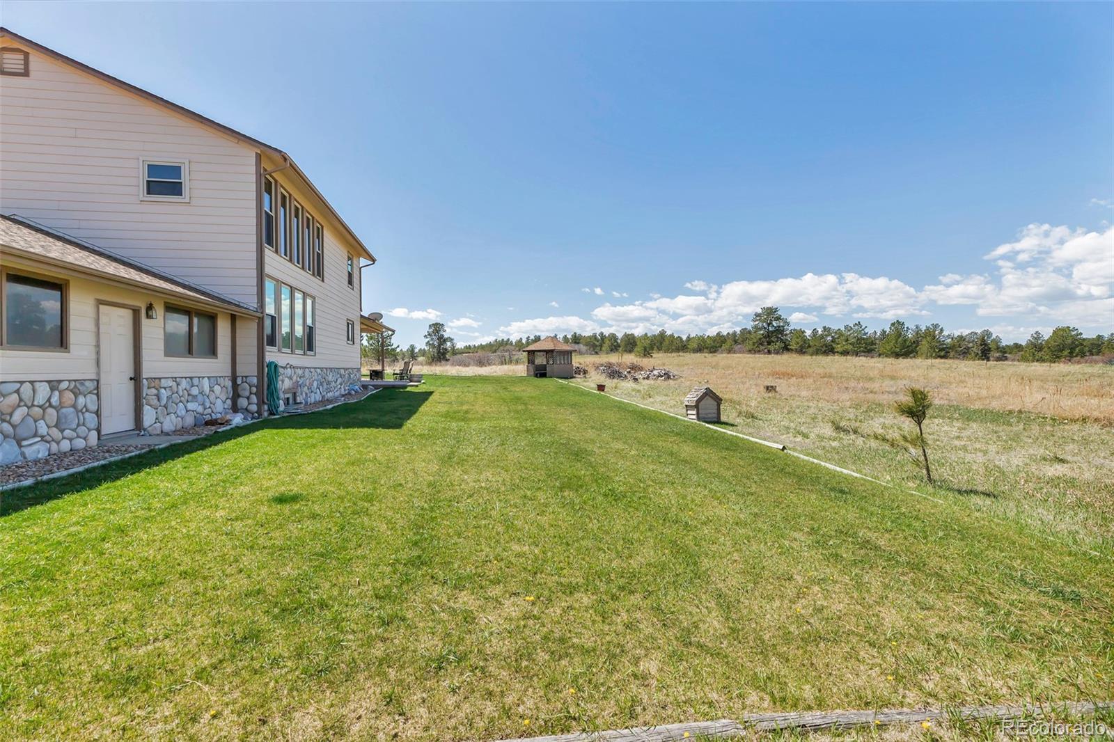 1493 Flintwood Road Franktown, CO 80116 - Photo 18 of 31 a view of a lake with houses in the background