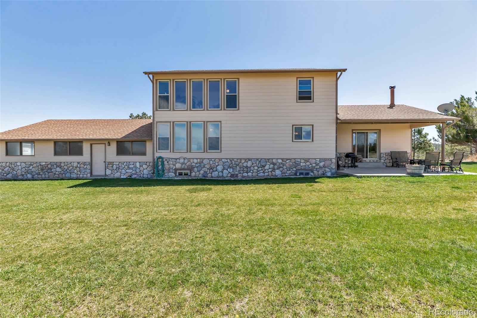 1493 Flintwood Road Franktown, CO 80116 - Photo 20 of 31 a front view of a house with a yard table and chairs