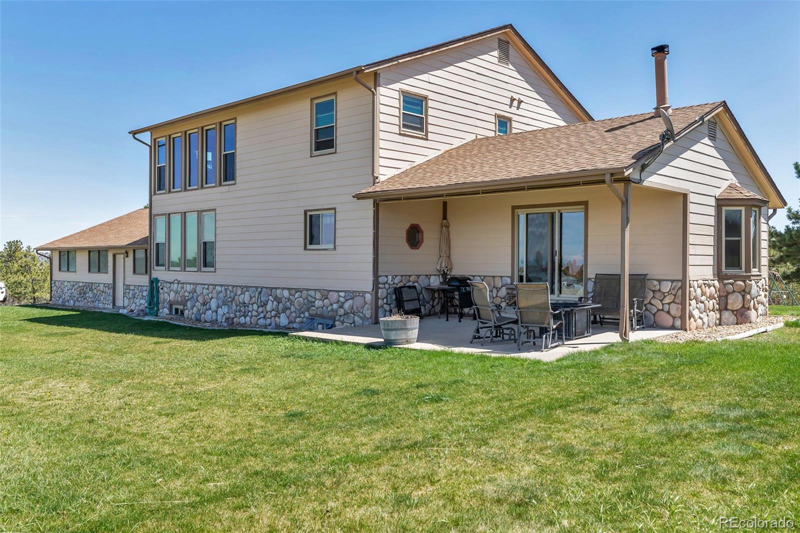1493 Flintwood Road Franktown, CO 80116 - Photo 21 of 31 a view of a house with a yard and sitting area