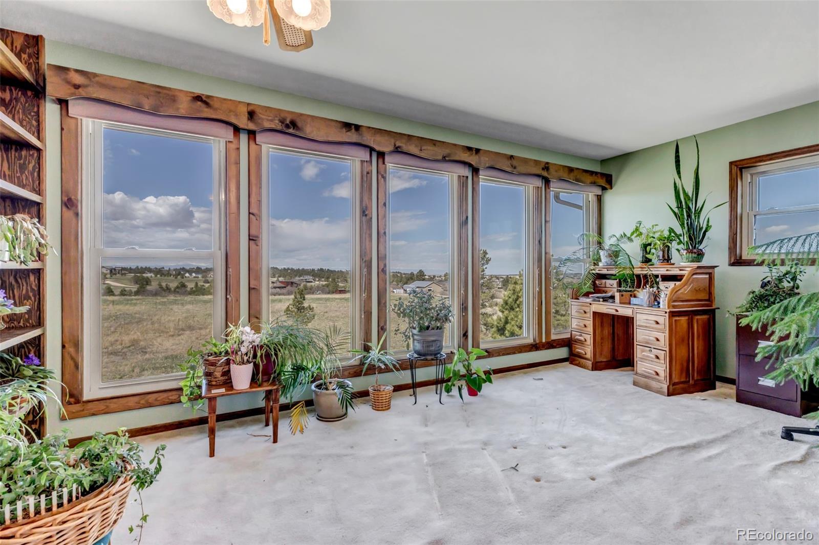 1493 Flintwood Road Franktown, CO 80116 - Photo 26 of 31 a living room with furniture and a floor to ceiling window