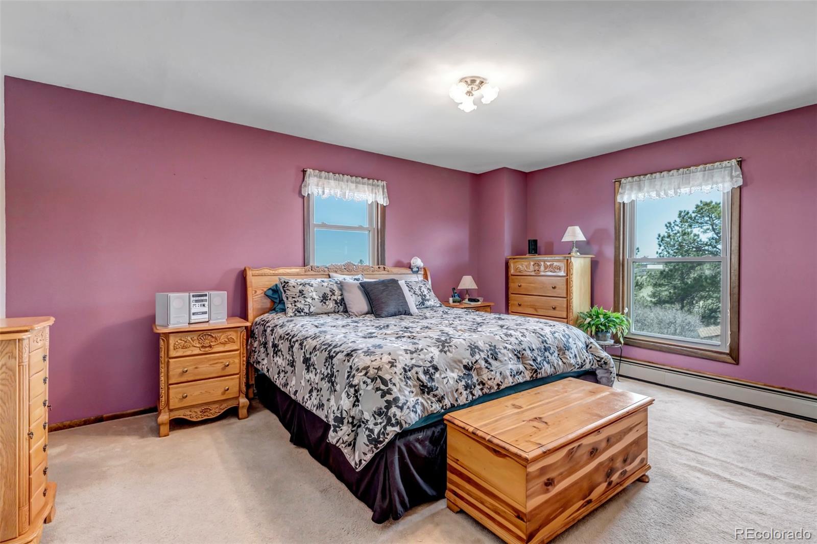 1493 Flintwood Road Franktown, CO 80116 - Photo 28 of 31 a spacious bedroom with a bed and a window