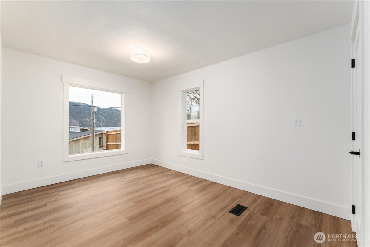 124 Boetzke Avenue Manson, WA 98831 - Photo 16 of 36 an empty room with wooden floor and windows