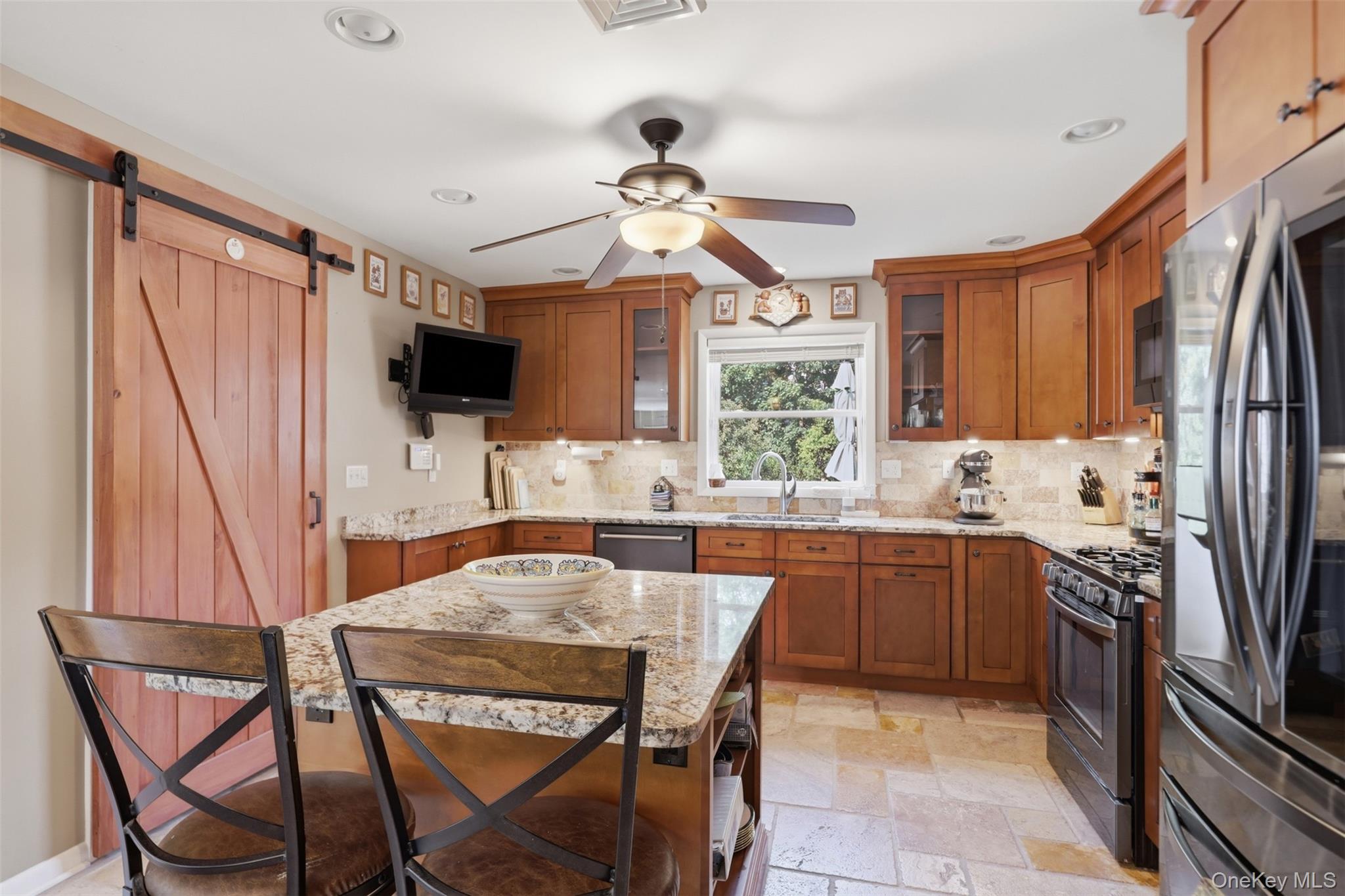 1 Hiko Place Fishkill, NY 12524 - Photo 11 of 41 Kitchen featuring a large central island with a granite countertop, wood-finish cabinetry, stone tile flooring, and a barn door entry
