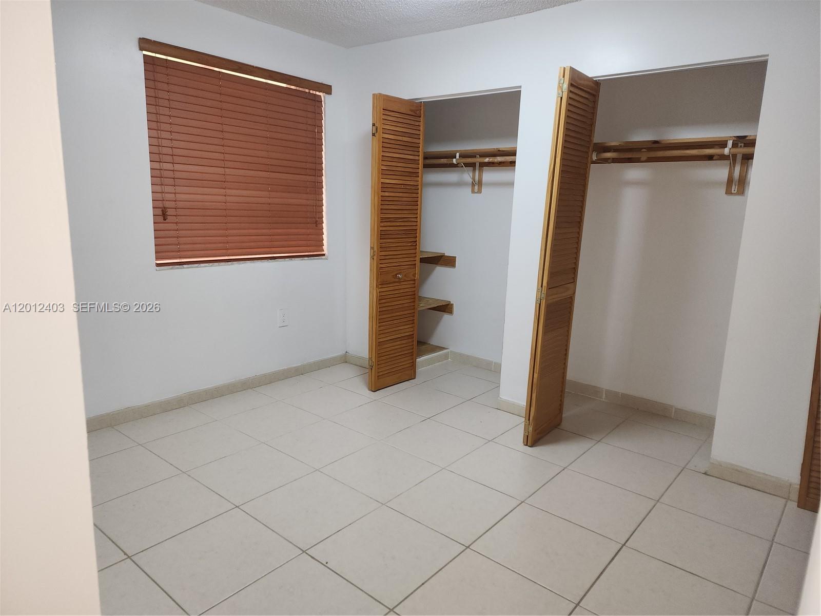 8990 Southwest 24th Street, Unit 19 Miami, FL 33165 - Photo 12 of 16 an empty room with walk in closet and mirror