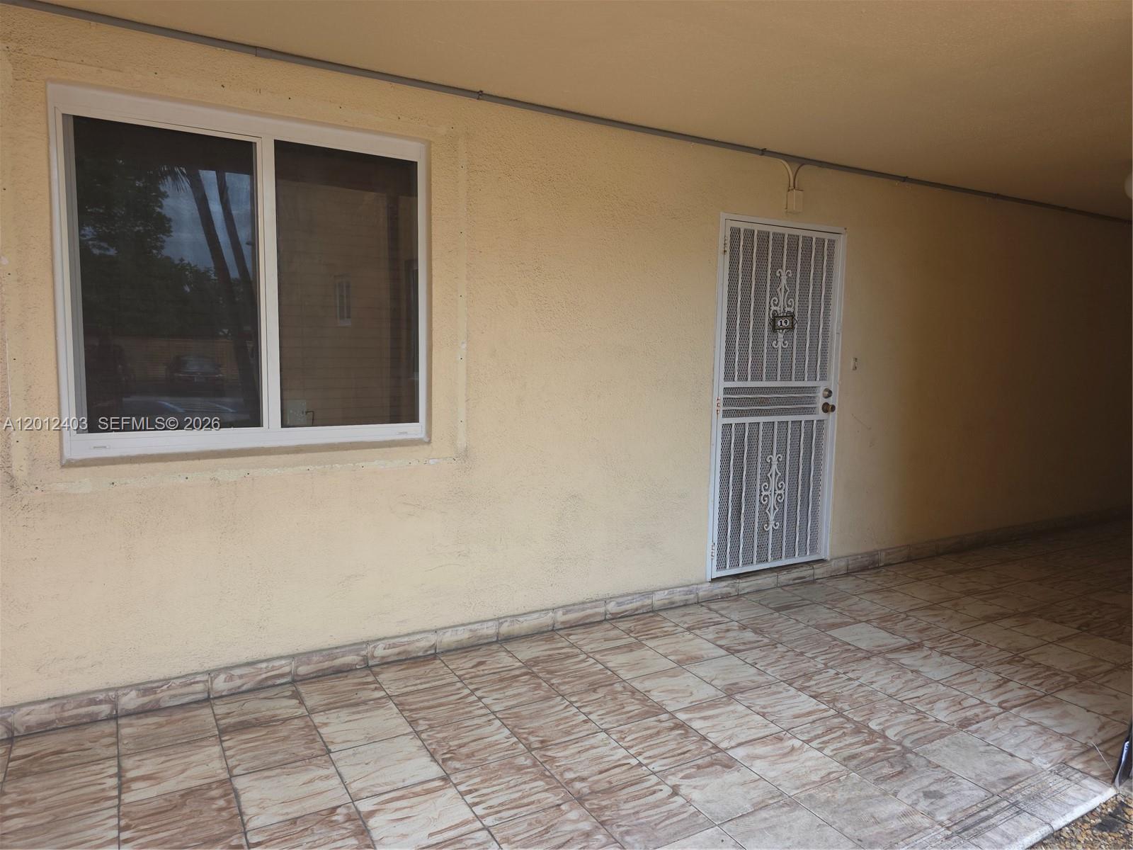 8990 Southwest 24th Street, Unit 19 Miami, FL 33165 - Photo 2 of 16 a view of an empty room with window and wooden floor