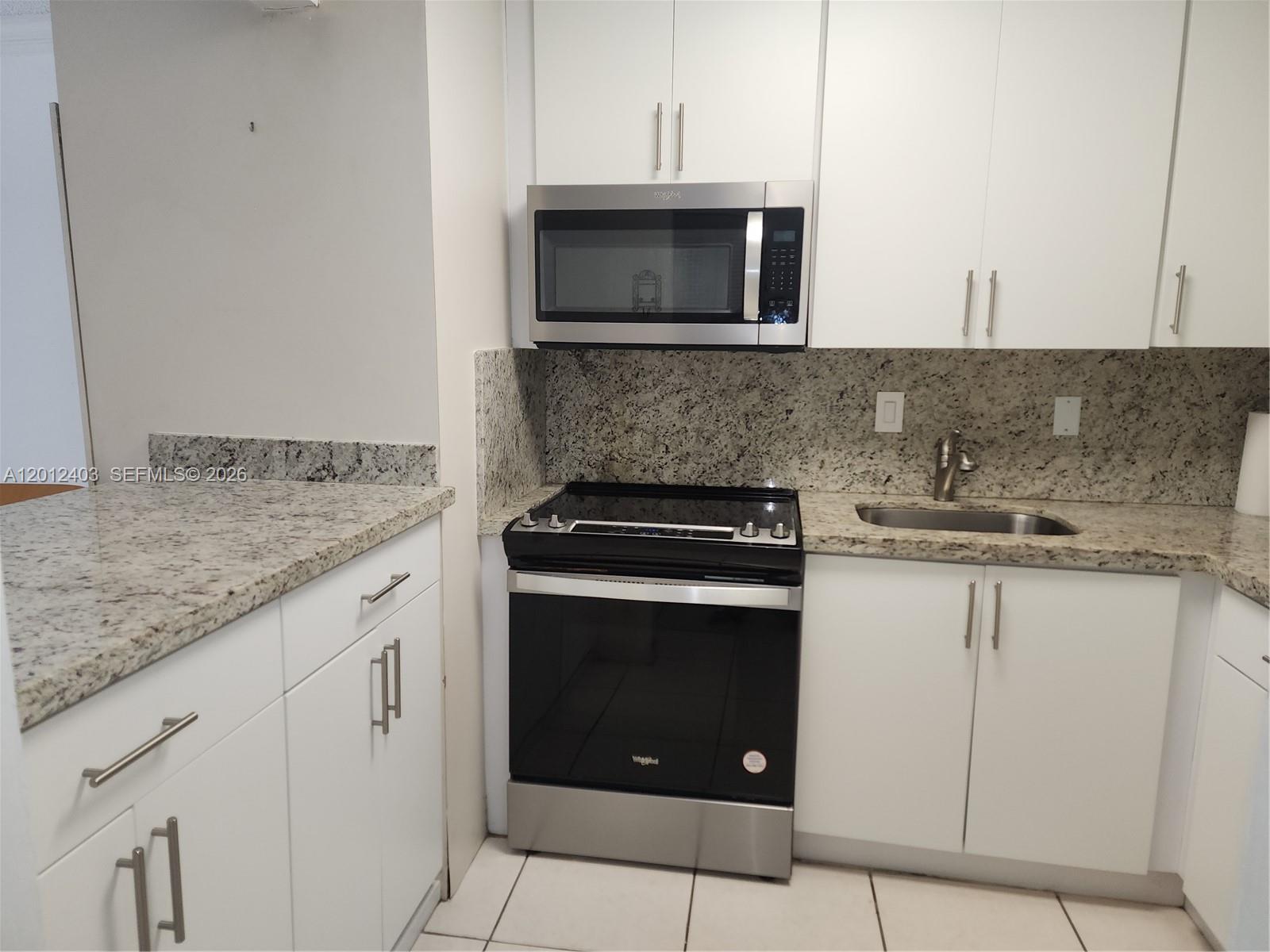 8990 Southwest 24th Street, Unit 19 Miami, FL 33165 - Photo 4 of 16 a kitchen with stainless steel appliances granite countertop a stove microwave and sink