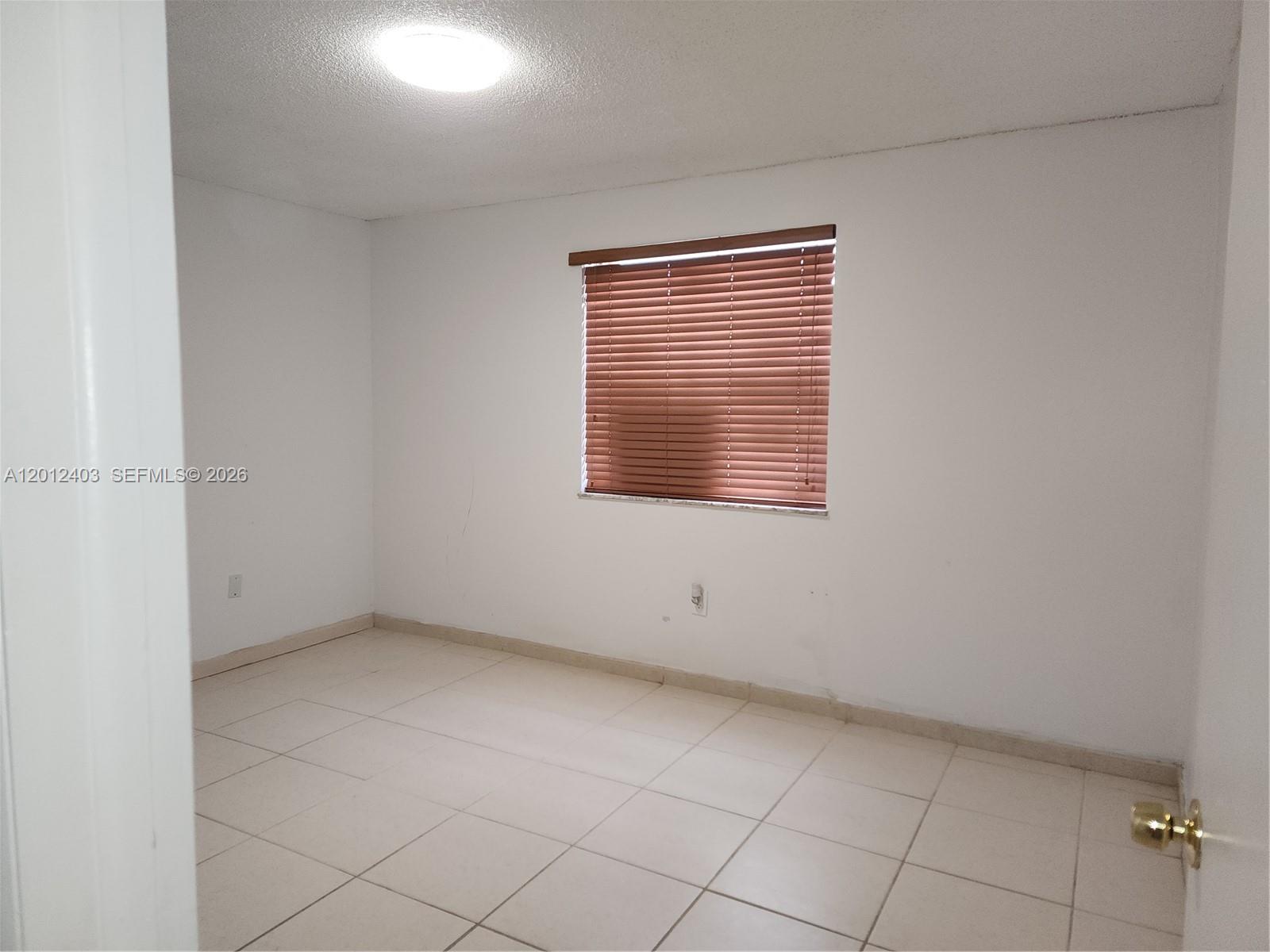 8990 Southwest 24th Street, Unit 19 Miami, FL 33165 - Photo 7 of 16 a view of an empty room with a window