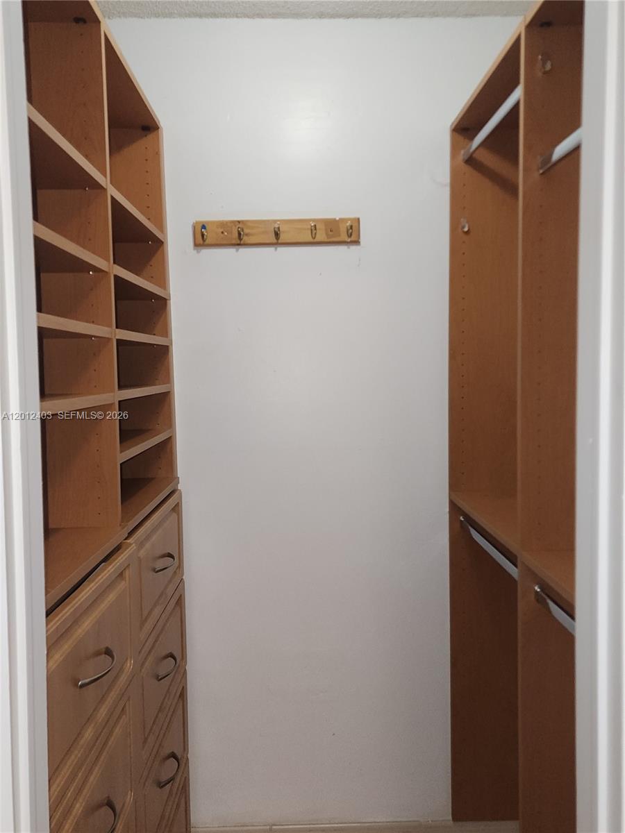 8990 Southwest 24th Street, Unit 19 Miami, FL 33165 - Photo 10 of 16 a view of walk in closet with empty racks