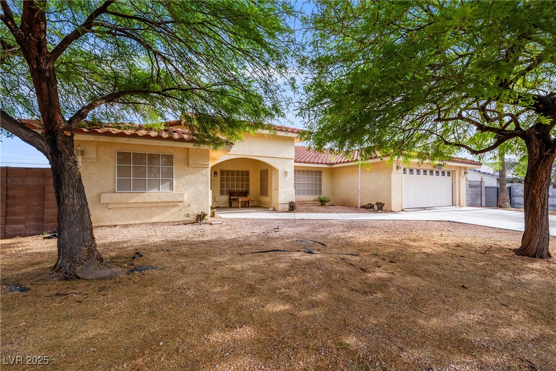 3481 Winery Road Pahrump, NV 89048 - Photo 1 of 34 Mediterranean / spanish-style house featuring stucco siding, a tile roof, an attached garage, and concrete driveway