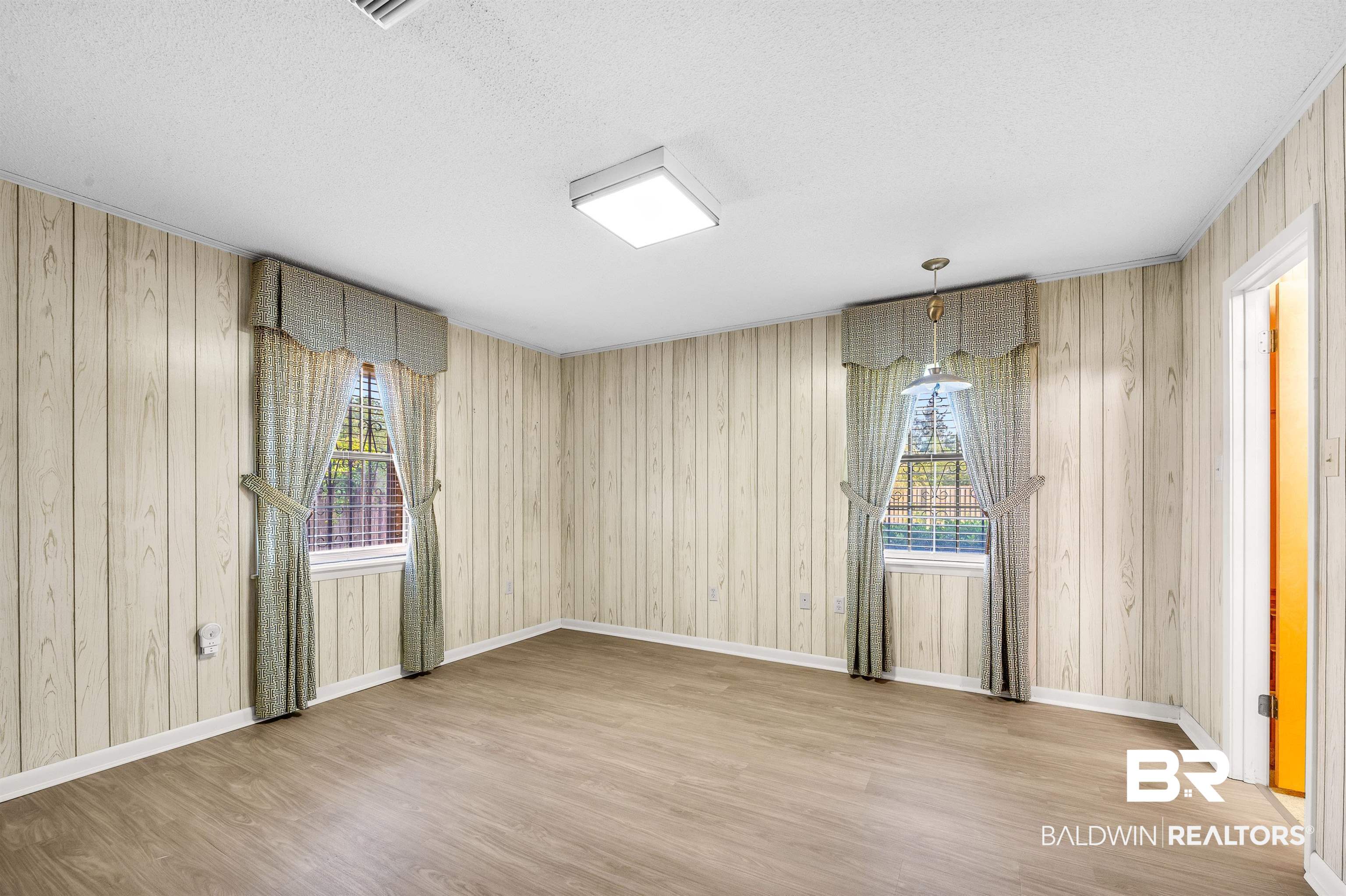 610 East Walker Avenue Foley, AL 36535 - Photo 30 of 38 Unfurnished room featuring wood finished floors, a textured ceiling, and wooden walls