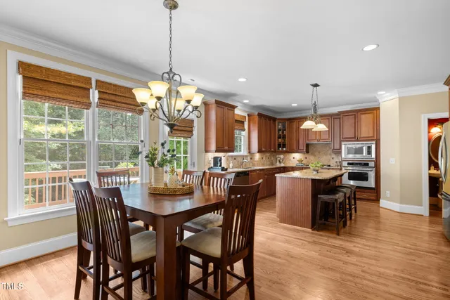 a kitchen with kitchen island granite countertop a center island a refrigerator and a dining table