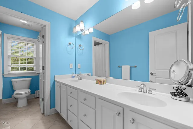 an empty room with windows and chandelier fan