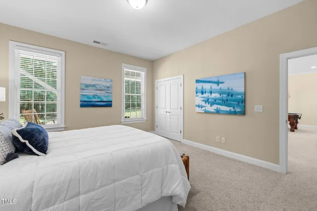 a bedroom with a bed and potted plant next to a window