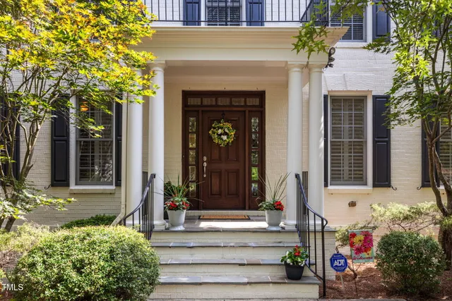 a front view of a house with a tree
