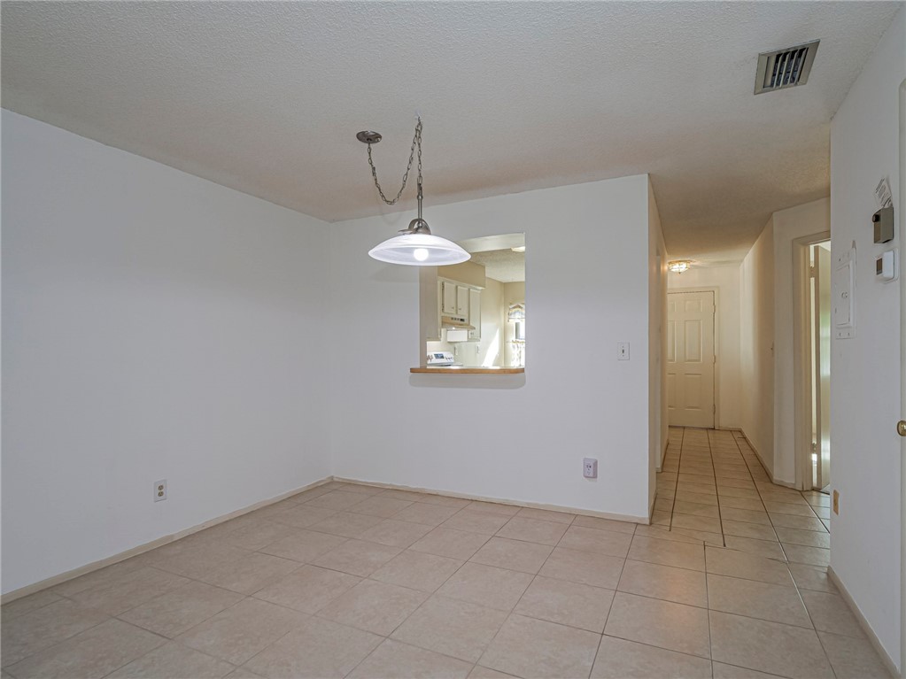 6006 Indrio Road, Unit B4 Fort Pierce, FL 34951 - Photo 14 of 36 a view of an empty room with a chandelier