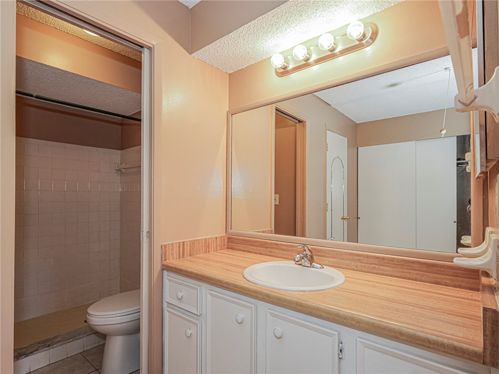 6006 Indrio Road, Unit B4 Fort Pierce, FL 34951 - Photo 18 of 36 a bathroom with a granite countertop sink toilet and a mirror