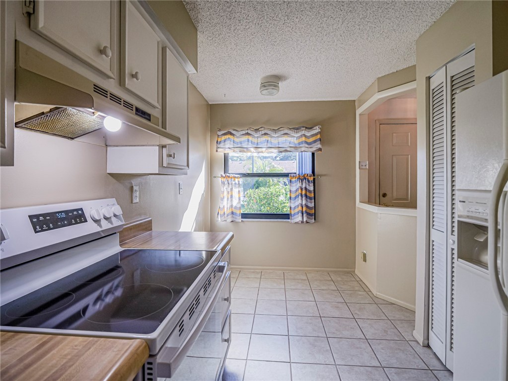 6006 Indrio Road, Unit B4 Fort Pierce, FL 34951 - Photo 8 of 36 a kitchen with stainless steel appliances granite countertop a refrigerator and a stove