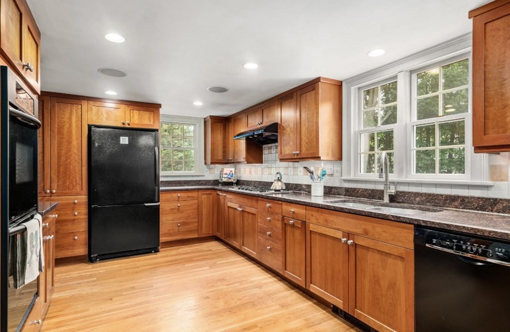 217 Conant Road Weston, MA 02493 - Photo 12 of 30 a kitchen with stainless steel appliances granite countertop a refrigerator a sink a stove and cabinets