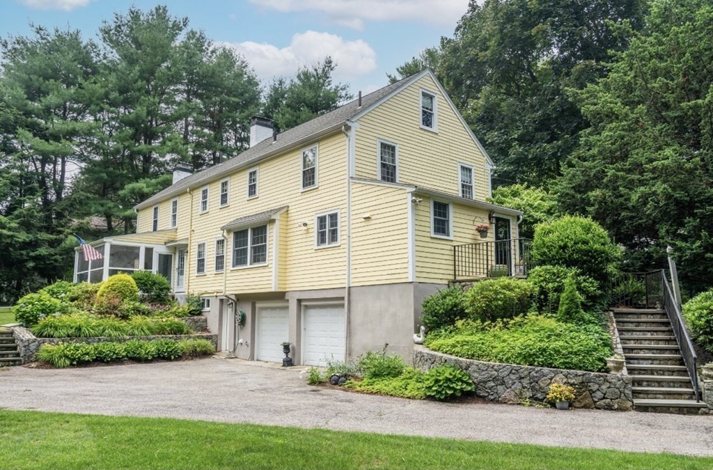 217 Conant Road Weston, MA 02493 - Photo 27 of 30 a view of a white house next to a yard with plants and trees