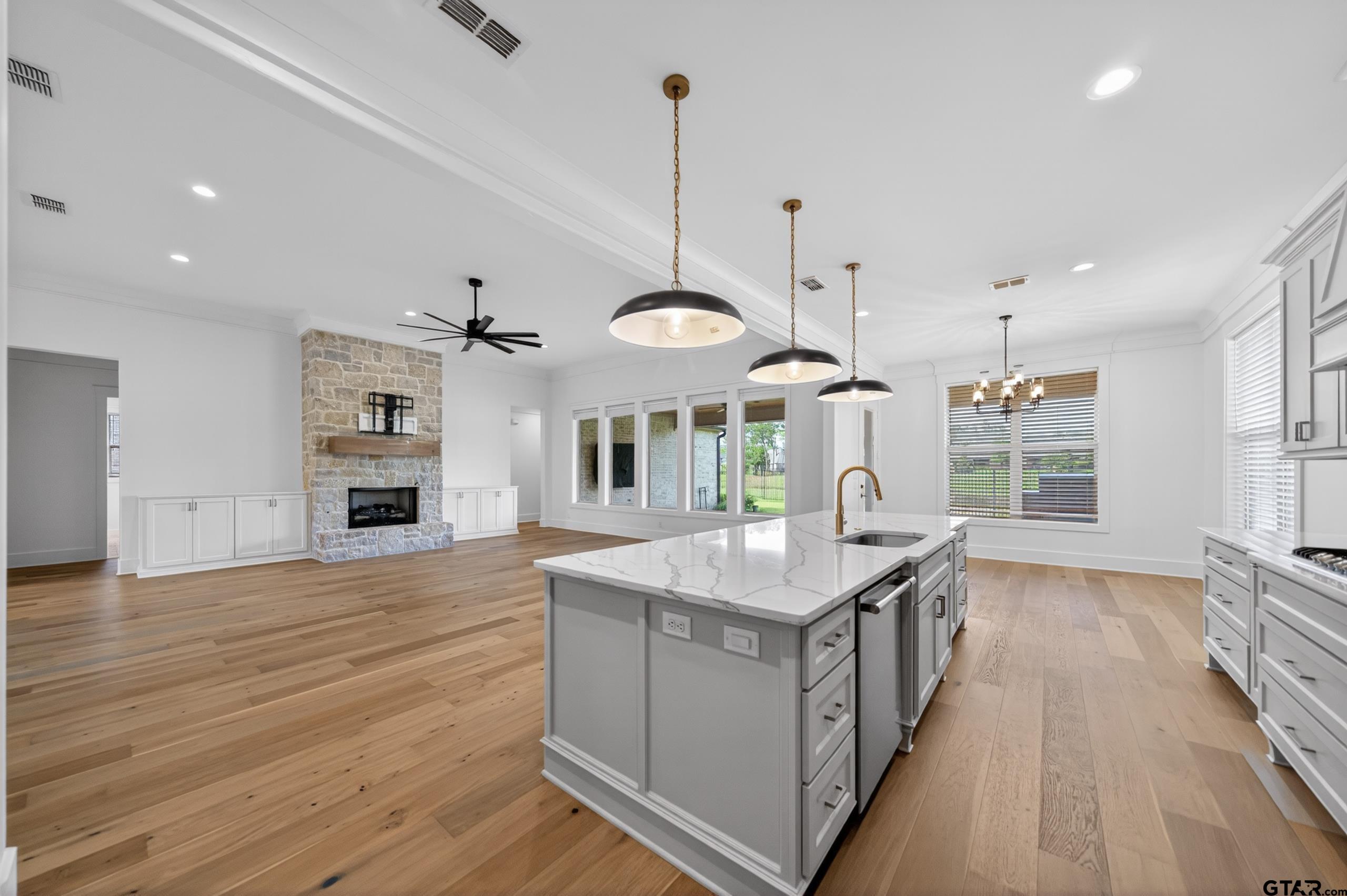 7517 Cross Gate Way Tyler, TX 75703 - Photo 9 of 47 an open kitchen with a sink stove and wooden floor