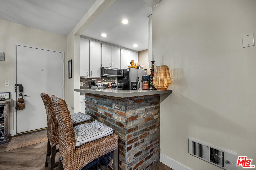 7740 Redlands Street, Unit G3092 Playa del Rey, CA 90293 - Photo 15 of 37 a kitchen with a dining table chairs and refrigerator