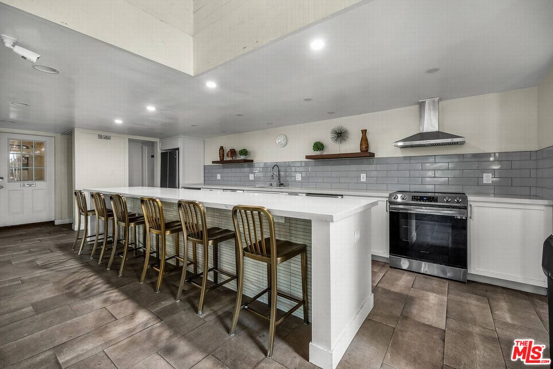 7740 Redlands Street, Unit G3092 Playa del Rey, CA 90293 - Photo 25 of 37 a large kitchen with stainless steel appliances granite countertop a stove a sink a dining table and chairs