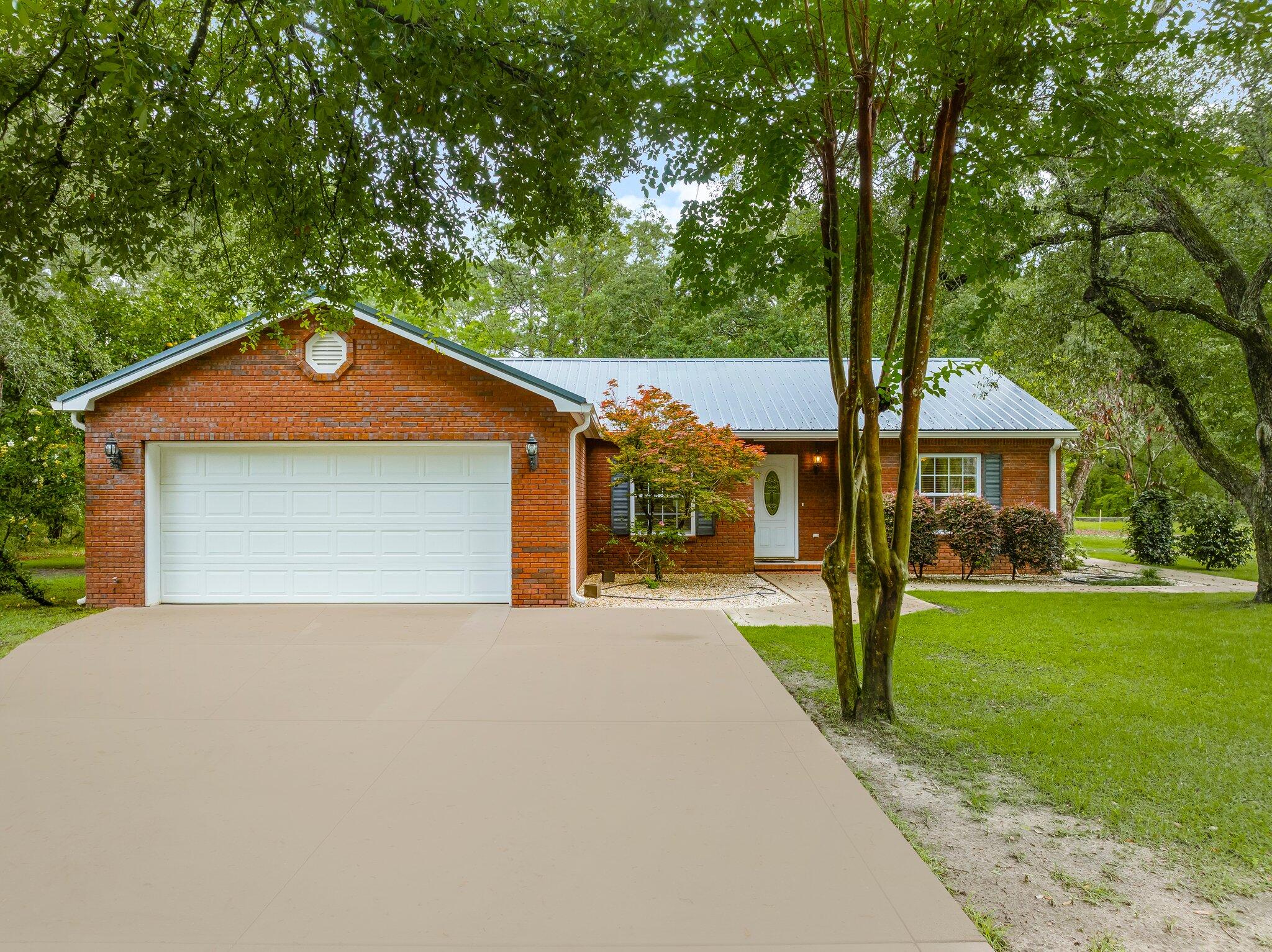 107 Rodney Drive Freeport, FL 32439 - Photo 1 of 34 a front view of a house with a yard and garage