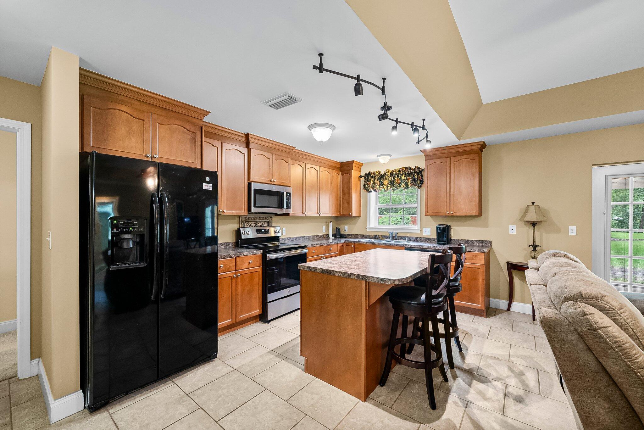 107 Rodney Drive Freeport, FL 32439 - Photo 10 of 34 a kitchen with stainless steel appliances granite countertop a refrigerator a sink dishwasher a stove and a dining table with wooden floor