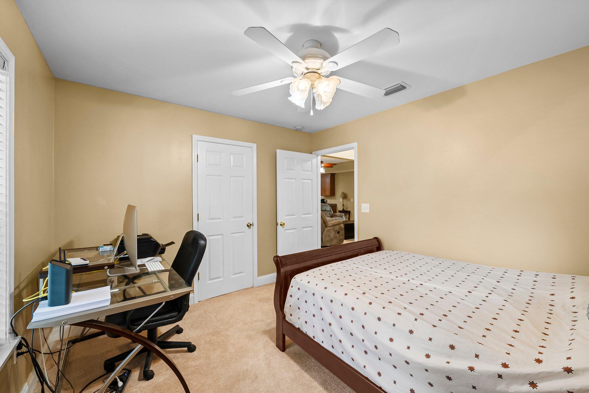 107 Rodney Drive Freeport, FL 32439 - Photo 15 of 34 a bedroom with a bed and a chandelier