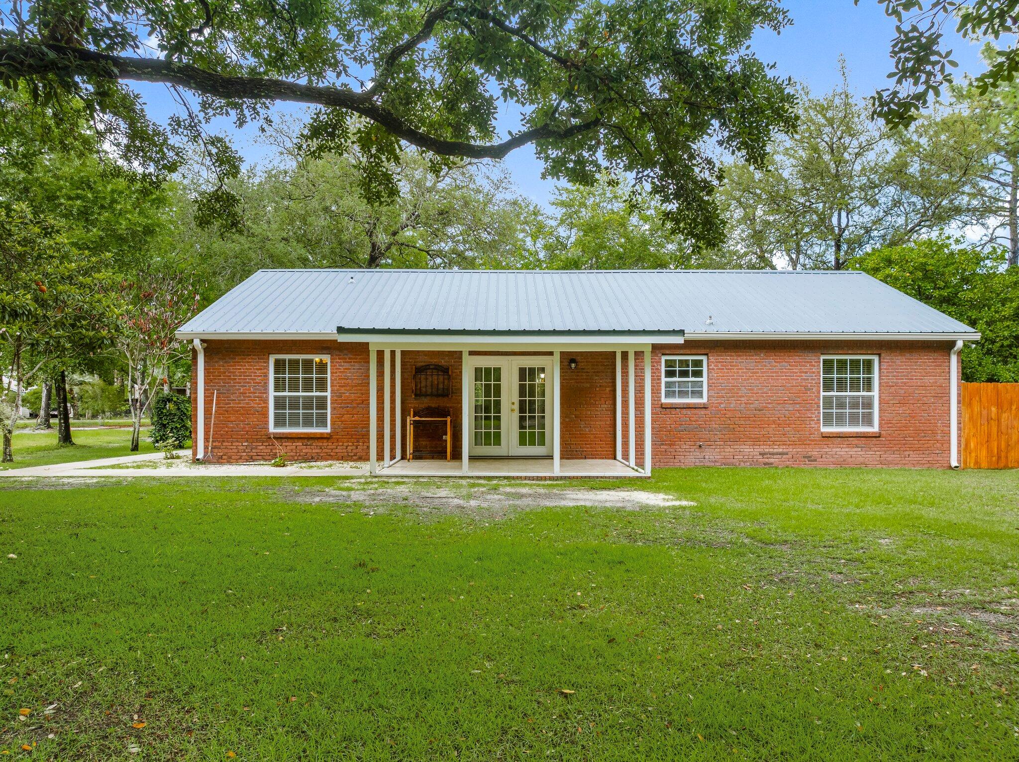 107 Rodney Drive Freeport, FL 32439 - Photo 26 of 34 a front view of a house with a garden