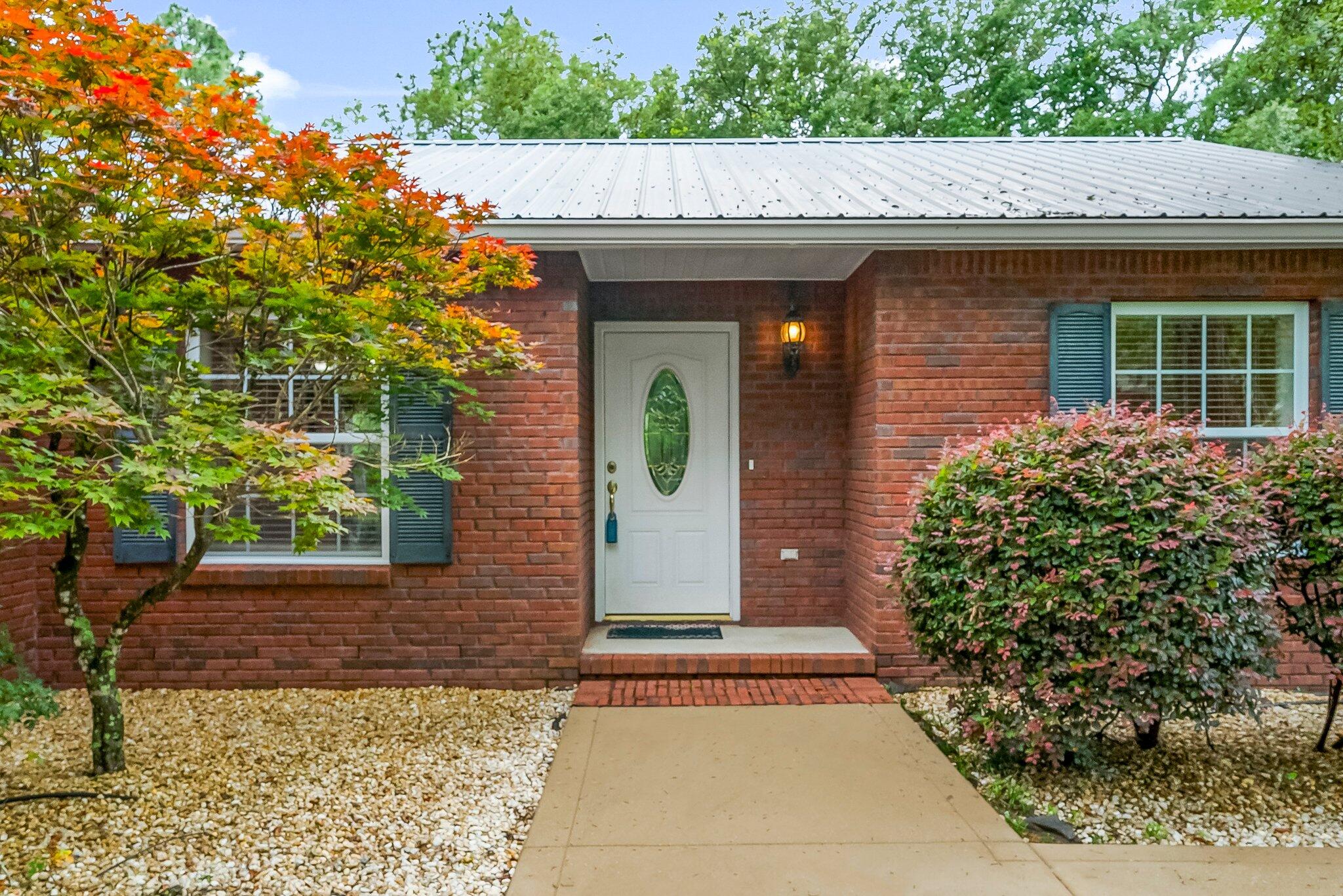 107 Rodney Drive Freeport, FL 32439 - Photo 4 of 34 a front view of a house with garden