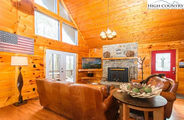 a living room with furniture a flat screen tv and a floor to ceiling window