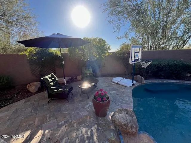 a view of a backyard with table and chairs under an umbrella